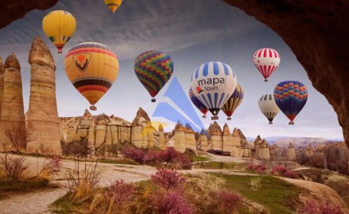 Hot air balloons flying over Cappadocia landscape at sunrise, Turkey