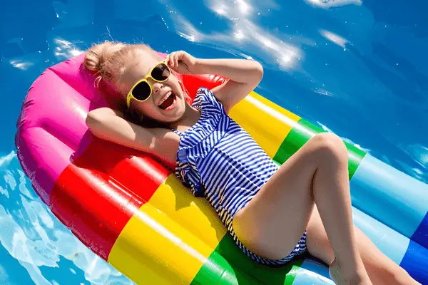 Happy child enjoying summer vacation on colorful pool float in Antalya, Turkey